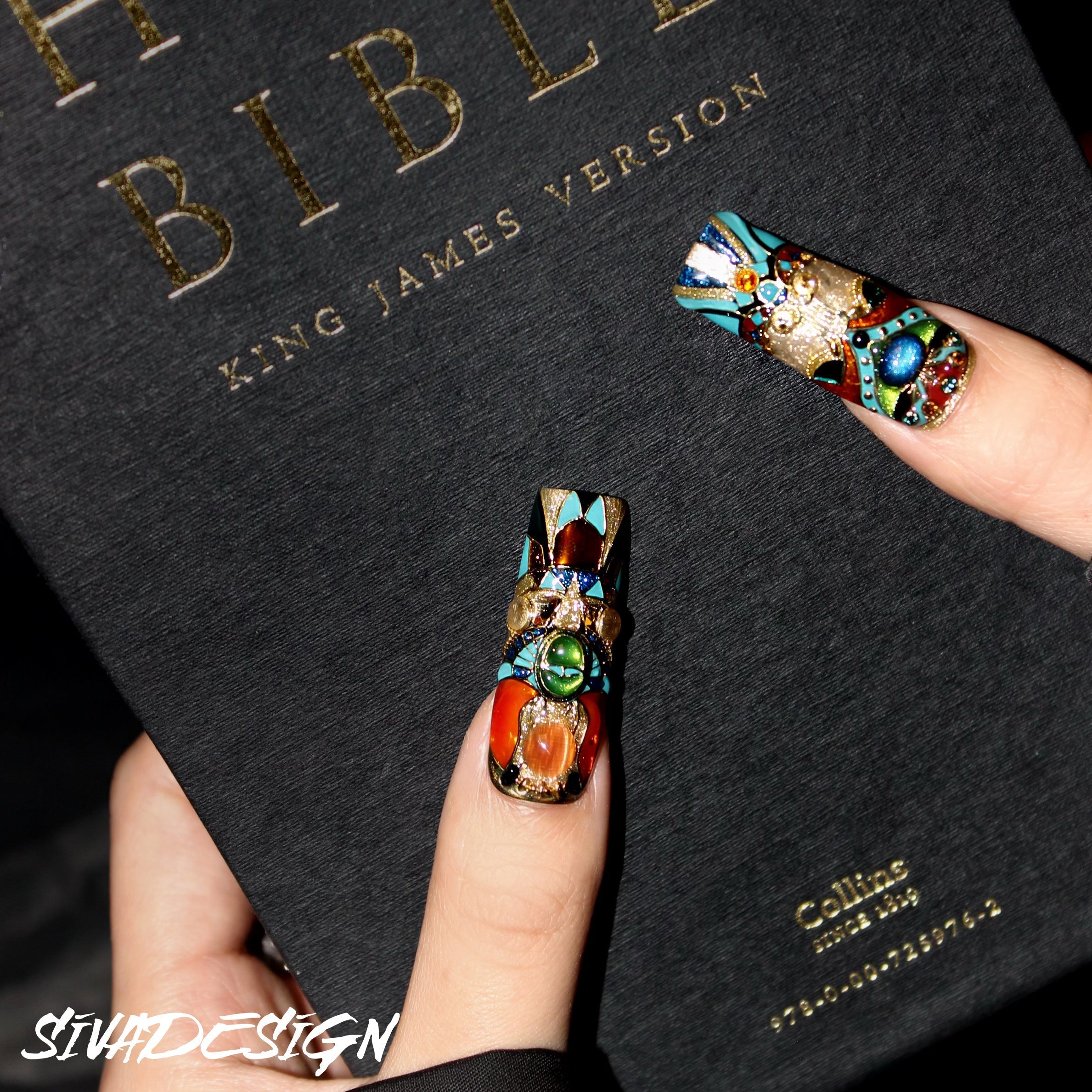 Custom luxury press-on nails with a blend of black, gold, and colorful gemstone accents